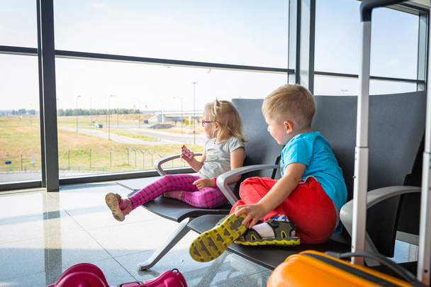 Little boy and girl waiting for boarding on the airport - Fotoğraf, Görsel