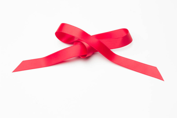 czerwona wstążka zrobić dekoracyjne więzi w prezenty świąteczne, prezenty urodzinowe, rocznice, prezenty w ogóle; czerwona wstążka na białym tle - Zdjęcie, obraz