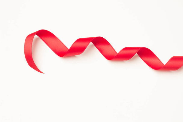 red ribbon to make decorative ties in Christmas gifts, birthday gifts, anniversaries, gifts in general; red ribbon on white background - 写真・画像