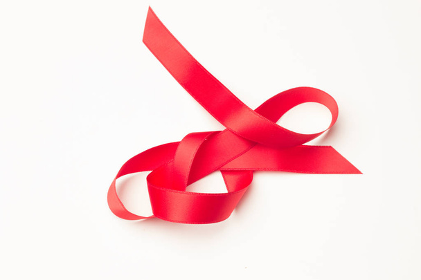 red ribbon to make decorative ties in Christmas gifts, birthday gifts, anniversaries, gifts in general; red ribbon on white background - Photo, image