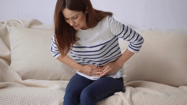 krásná žena trpící žaludeční bolestí doma - Záběry, video
