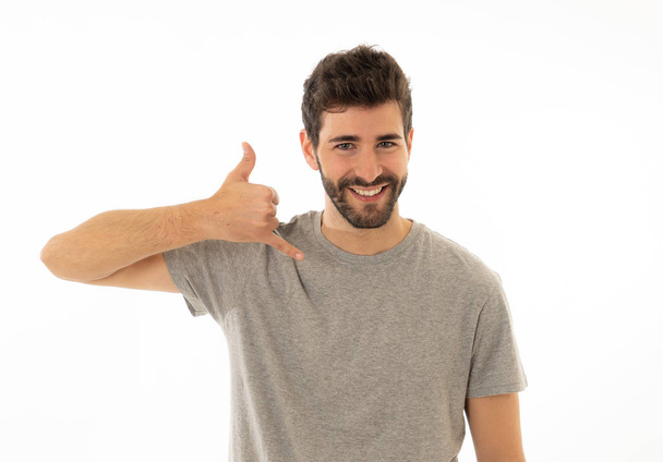 Give me a call. Portrait of attractive young man making call you gesture smiling with with hand shaped like mobile phone isolated on white background. Image friendly for advertising. - Foto, Bild