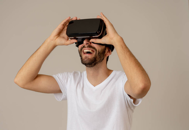 Casual bearded young man using VR headset glasses goggles feeling excited trying simulation, exploring virtual reality making gestures interacting with new 3D world. In new technology concept. - Foto, immagini