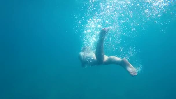 Κολυμπήστε υποβρύχια, όμορφο κορίτσι τουρίστρια με όμορφη λεία καταδύσεις δαπάνες καλοκαιρινές διακοπές στη θάλασσα ενεργά καταδύσεις κολυμπάει και βυθίζεται σε βάθη του ωκεανού απολαμβάνοντας τη ζωή στο φόντο του νερού - Πλάνα, βίντεο