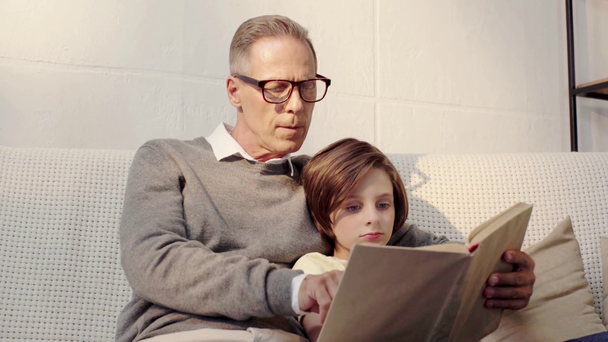 nagyapja és unokája könyv együtt a nappaliban - Felvétel, videó