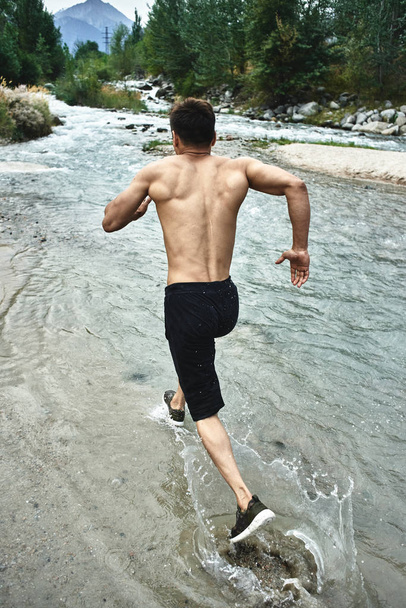 Asian athlete on a morning run on the river, Kazakh jogger in nature close-up  - Fotoğraf, Görsel