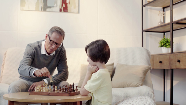Isoisä ja pojanpoika pelaavat shakkia olohuoneessa
 - Materiaali, video
