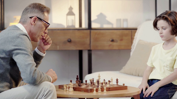 Avô e neto jogando xadrez na sala de estar
 - Filmagem, Vídeo