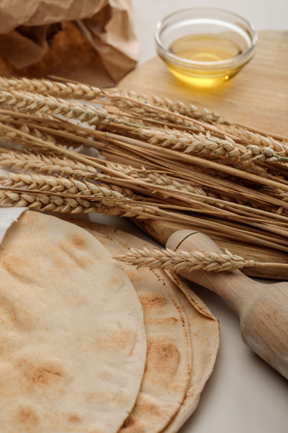 лаваш из хлеба рядом со скалкой и разделочной доской со шпинатом и маслом
 - Фото, изображение