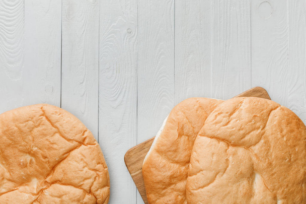 вид сверху на лаваш хлеб на белой деревянной поверхности
 - Фото, изображение