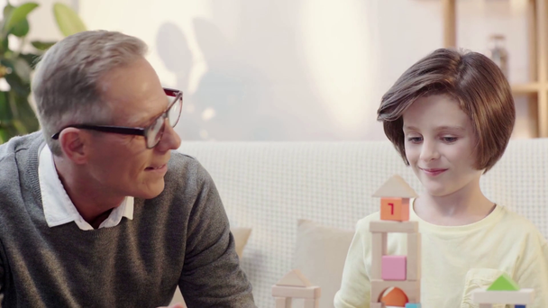grandfather and grandson playing with building blocks and giving high five - Imágenes, Vídeo