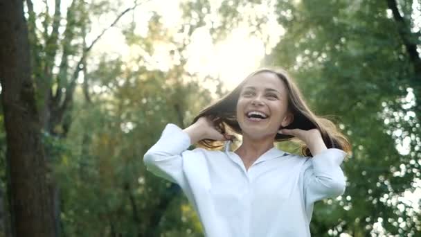 Close up portrait of Young brunette girl smiling. Happy awesome Woman with hair blowing in wind looking at camera and smiling. Slow motion. - Metraje, vídeo