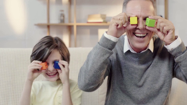 smích dědečka a vnuka při sestavování stavebních bloků na očích - Záběry, video