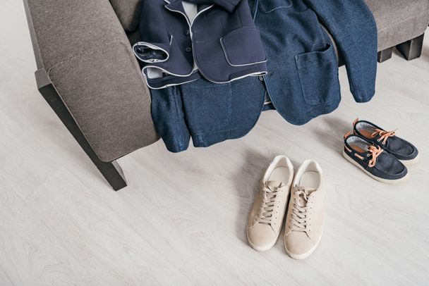 formal jackets on sofa and shoes on floor at home - Photo, Image