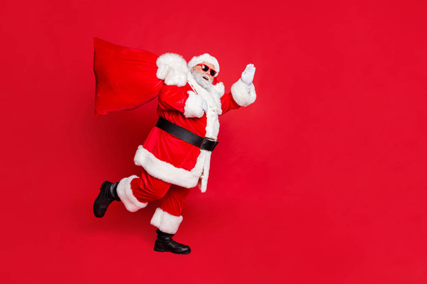 Full length body size view of cheerful cheery dreamy glad funky fat overweight plump gray-haired bearded man piggy backing gifts fairy waving greetings isolated over bright vivid shine red background - Foto, Imagen