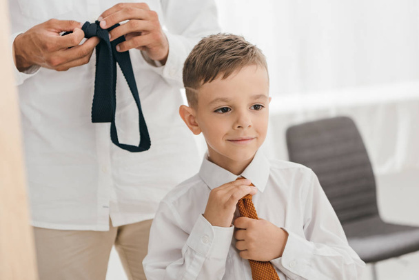 частичный взгляд на отца и сына в белых рубашках с галстуками
 - Фото, изображение