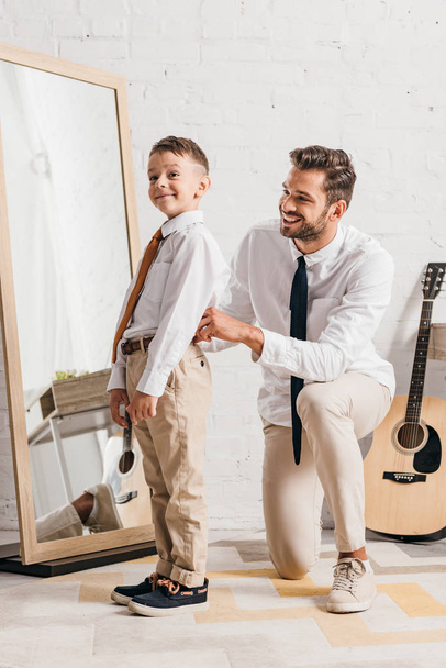 bearded dad helping son to get dressed at home - Photo, Image