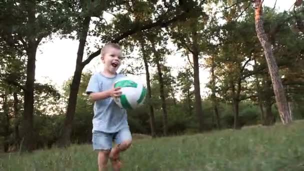 Een 3-jarige jongen raakt de bal hard en mist. Grappig geval met een kind. - Video