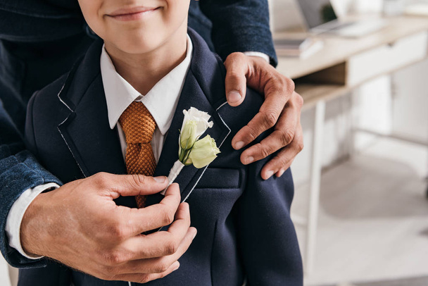 cropped view of dad and son in jacket with boutonniere - Photo, Image