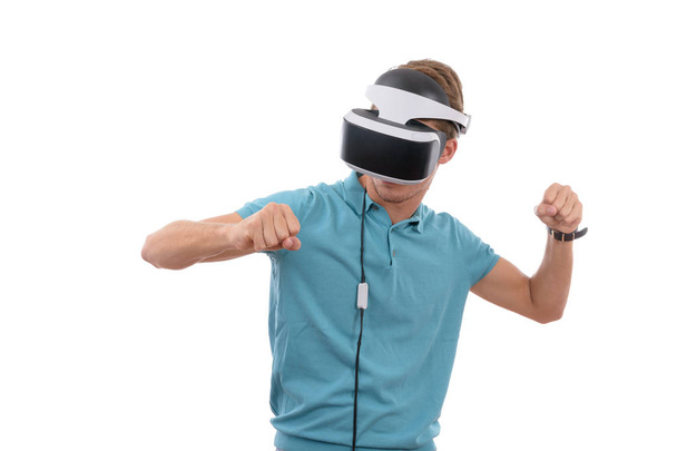 Caucasian young boy playing with virtual reality glasses dressed in a blue polo shirt isolated in white background - Fotó, kép