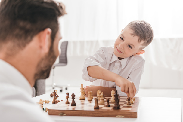 selective focus of dad and son playing chess together at home - Photo, Image