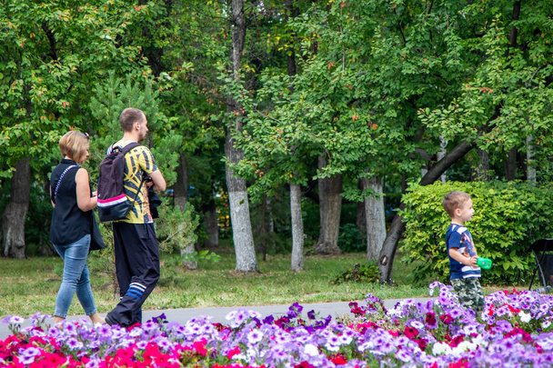 ペトロパブロフスク、カザフスタン - 8月23、2019:お父さんと息子は夏に公園を歩いています. - 写真・画像