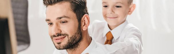 panoramic shot of smiling son and dad in formal wear - Fotografie, Obrázek