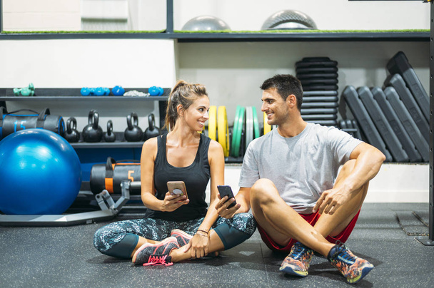 Middle-aged couple with the phone in gym - Photo, Image