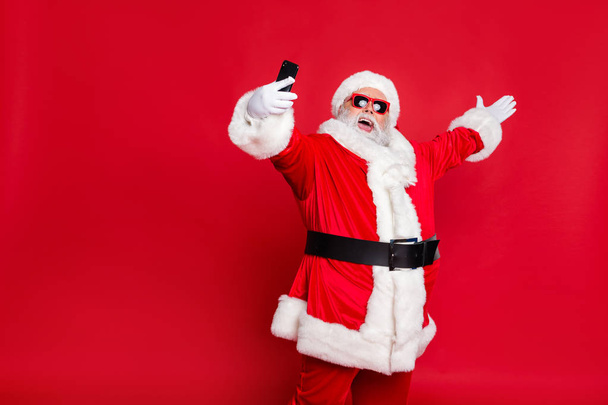 Portrait of his he nice attractive cheerful cheery positive glad friendly hospitable bearded Santa pouted lips taking making selfie blog blogger isolated over bright vivid shine red background - Фото, изображение
