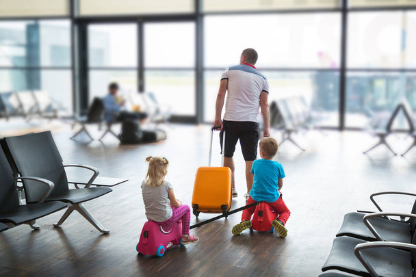 Father with two children in the airport terminal fly together on vacation - Φωτογραφία, εικόνα