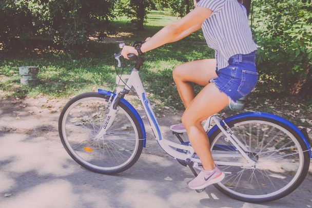 Bella giovane donna a cavallo della bicicletta nel parco
  - Foto, immagini