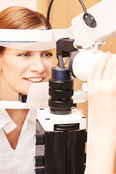 Eye ophthalmologist exam. Eyesight recovery. Astigmatism check concept. Ophthalmology diagmostic device. Beauty girl portrait in clinic - Foto, imagen