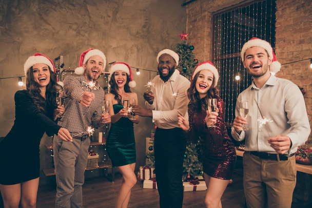 Portrait of funny fellows with santa claus hat cap hold champagne bengal lights celebrate christmas holidays x-mas night party in house indoors - Fotó, kép