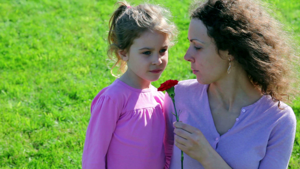 Mother hold red flower and tell about WWII to her little daughter - Footage, Video