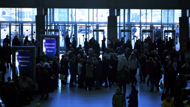多くの人々 が駅でガラスの壁の入口付近を歩く - 映像、動画