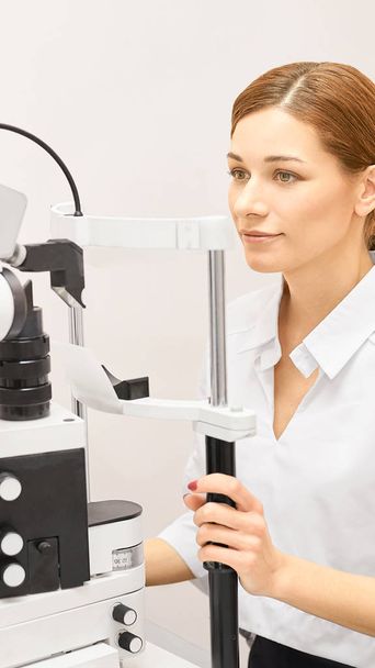 Eye ophthalmologist exam. Eyesight recovery. Astigmatism check concept. Ophthalmology diagmostic device. Beauty girl portrait in clinic - 写真・画像