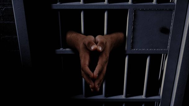 Gevangenis cel en zwarte handen - Foto, afbeelding