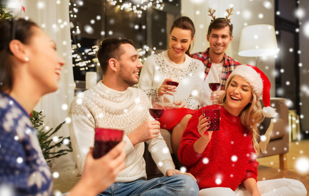 vrienden die Kerstmis vieren en wijn drinken - Foto, afbeelding