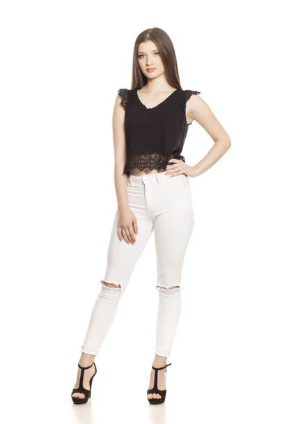 Young woman in white jeans and high heels on white background - Photo, Image