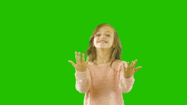 Playful little girl with curly hair looking at the camera smiling waving her arms calling her pet or cat to her pet, emotions, child shooting, shooting on an isolated background - Footage, Video