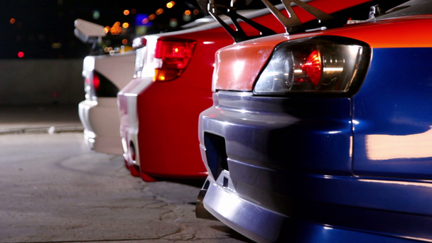 drie auto's met kleurrijke sport ontwerpen bij nacht - Video