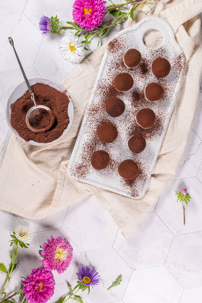Fijne chocolade truffels op witte keramische plaat. - Foto, afbeelding