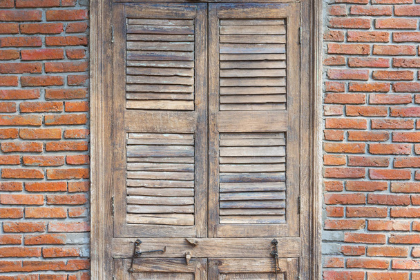 Zárt fából készült ajtó piros tégla fal régi szüreti házban. Ab - Fotó, kép