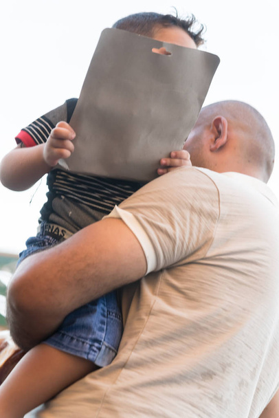 Baghdad, Iraq - July 06, 2019: Father holding son with toy  - Photo, Image
