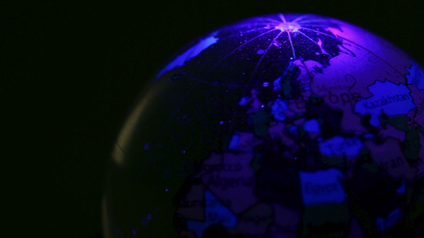 Läpinäkyvä pallo, jossa on maailmankartta, pyörii värivalossa
 - Materiaali, video