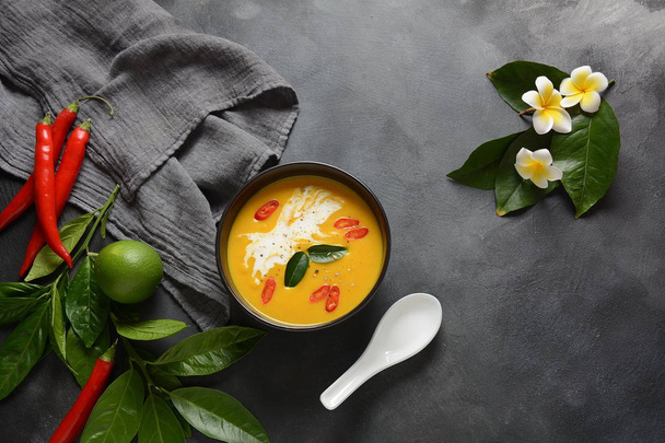 Thai spicy pumpkin and coconut milk soup with kaffir lime leaves , red chili and galangal roots powder. Vegan, healthy food, gluten-free. Paleo-diet - Foto, Imagem