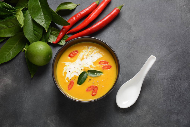 Thai spicy pumpkin and coconut milk soup with kaffir lime leaves , red chili and galangal roots powder. Vegan, healthy food, gluten-free. Paleo-diet - Foto, Imagem