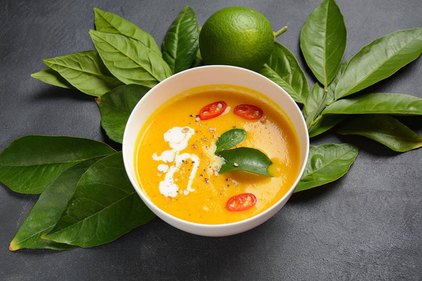 Thai spicy pumpkin and coconut milk soup with kaffir lime leaves , red chili and galangal roots powder. Vegan, healthy food, gluten-free. Paleo-diet - Фото, изображение