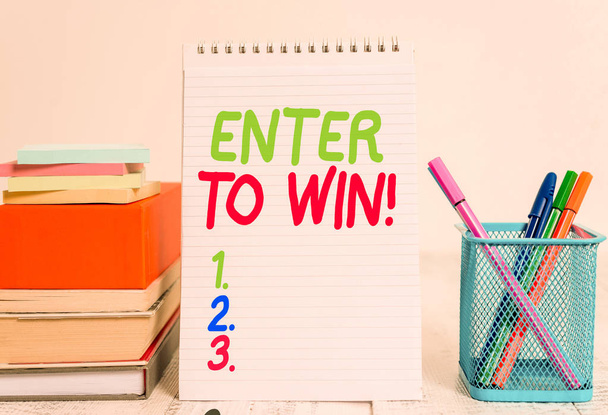 Text sign showing Enter To Win. Conceptual photo exchanging something value for prize chance winning prize Pens metal holder stacked note pads books square box spiral wooden table. - Zdjęcie, obraz