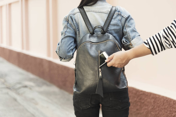 Dief stelen mobiel van Traveller tas op straat. Afbeelding voor  - Foto, afbeelding